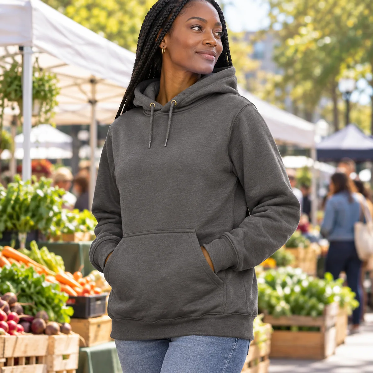 Black woman wearing a carbon heather Carhartt Loose-Fit Midweight Hoodie at a farmers market.