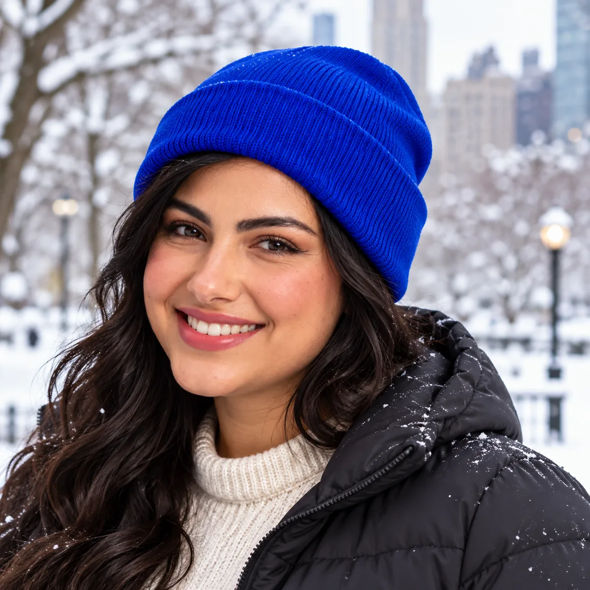 Woman wearing a royal blue blank cuffed beanie at a snowy city park.