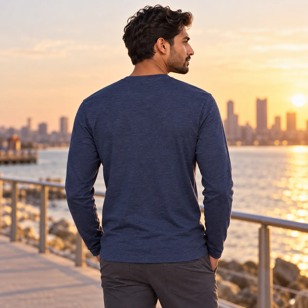 Man wearing the heathered navy long-sleeve District Very Important Tee, shown from behind on a waterfront path.