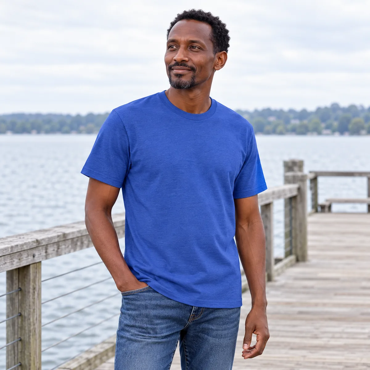 Model wearing a royal frost District Very Important Tee at a lakeside pier.