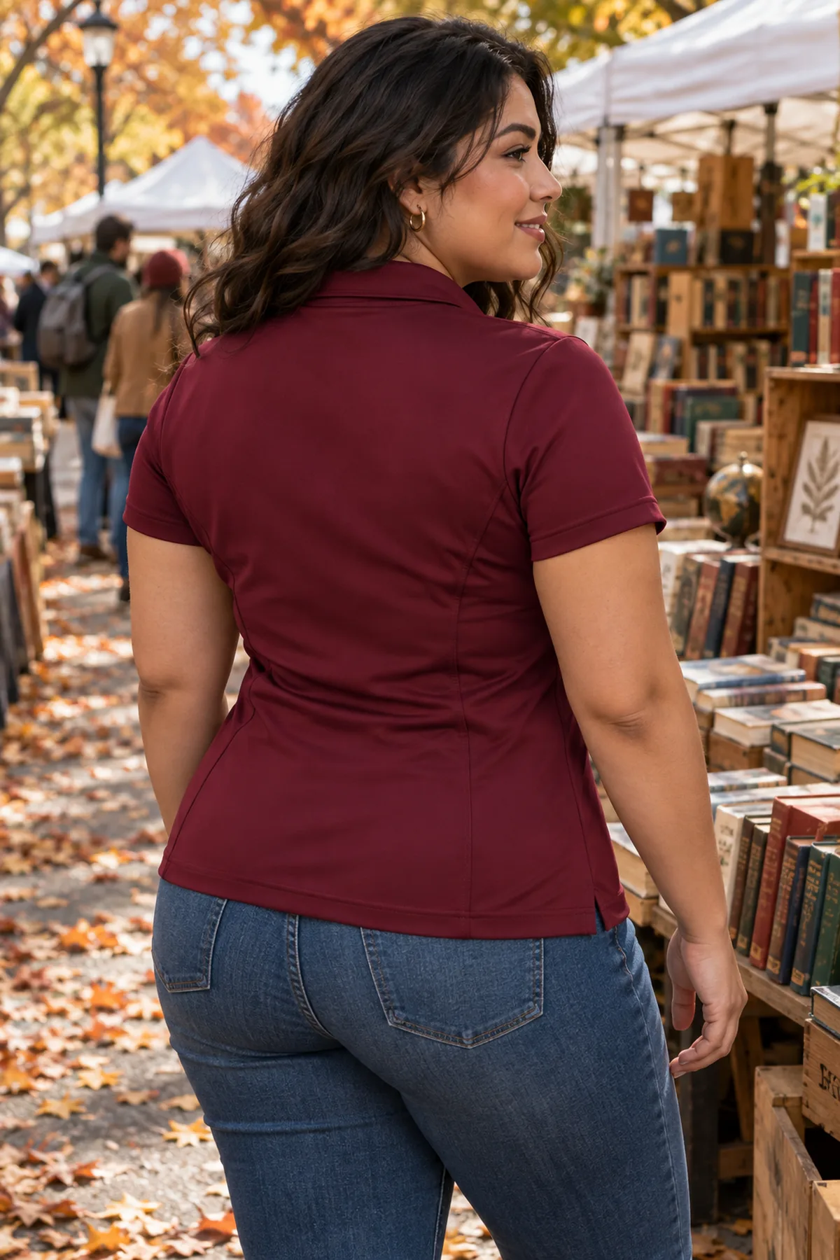 Woman wearing a maroon Elevate Moreno polo at an autumn book market, shown from behind.