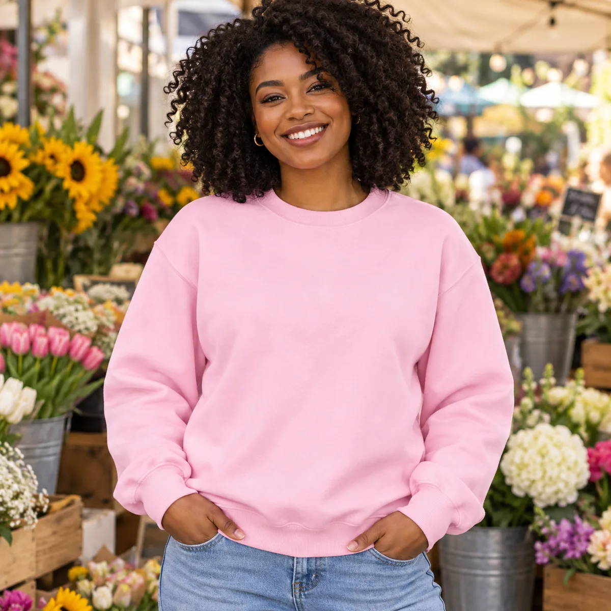 Woman wearing a light pink Gildan Heavy Blend sweatshirt at a flower market; blank front.