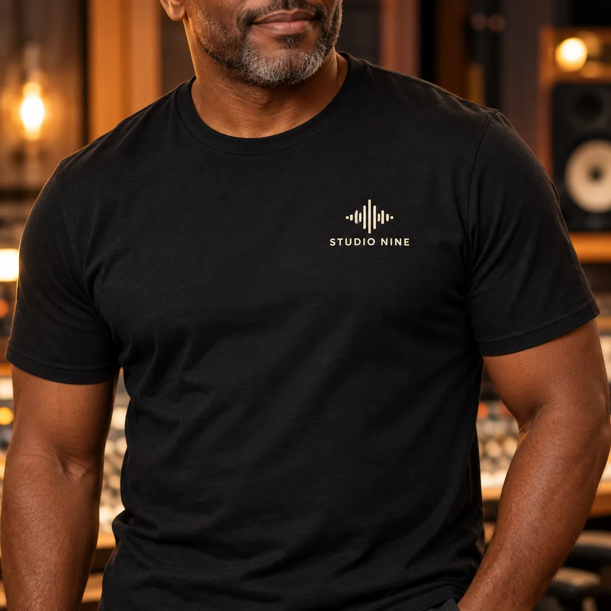 Close-up of sample Studio Nine artwork on a black Gildan Softstyle T-shirt worn by a model.