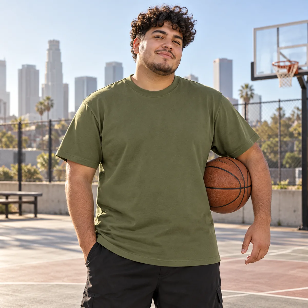 Model wearing an olive Gildan Ultra Cotton unisex T-shirt at an outdoor basketball court.