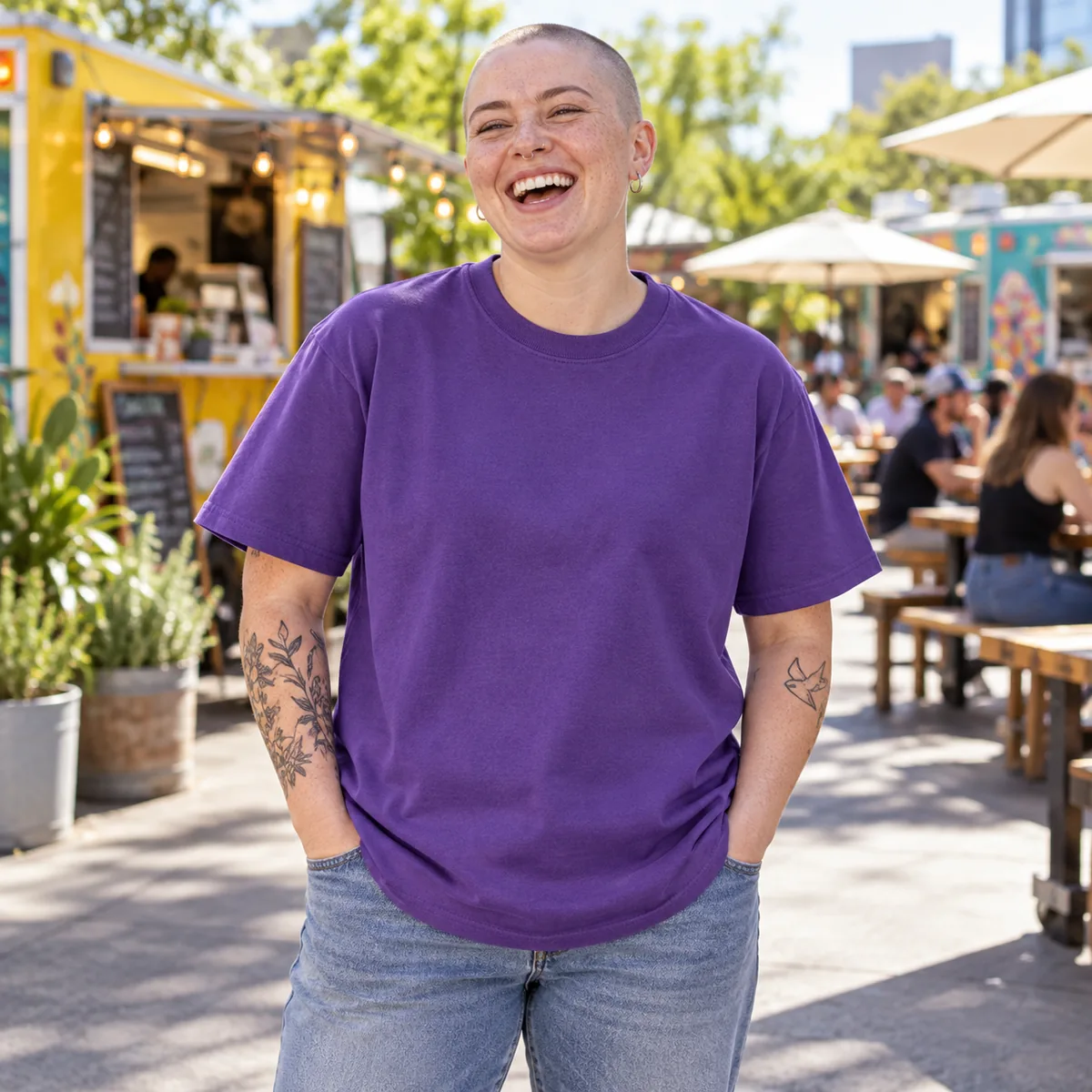 Model wearing a purple Gildan Ultra Cotton unisex T-shirt at an outdoor food truck plaza.