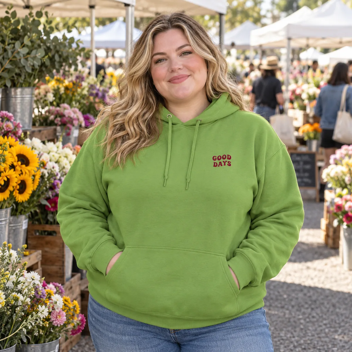 White woman wearing a kiwi JERZEES NuBlend hoodie with fictional Good Days chest print at a flower market.