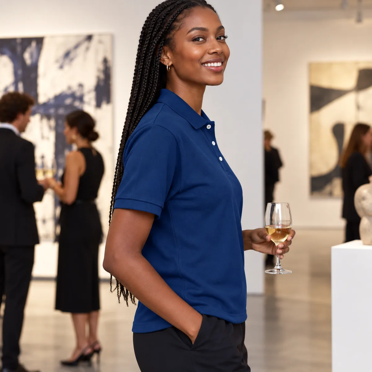 Woman wearing a navy piqué polo at a gallery opening, shown in side profile.