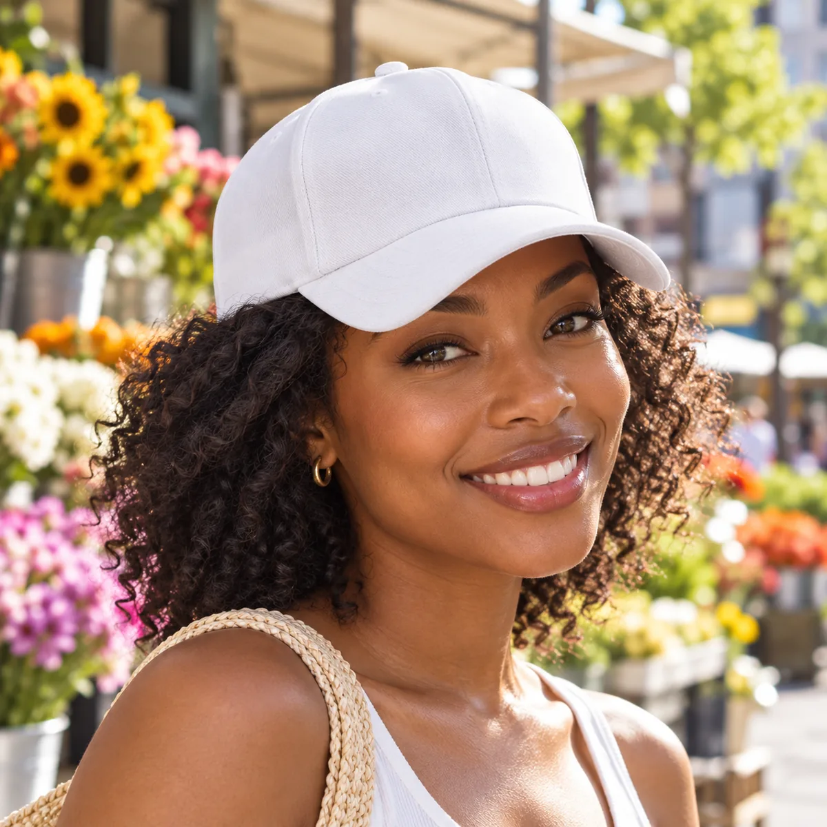 Black woman wearing a white blank printed baseball cap at a sunny flower market.