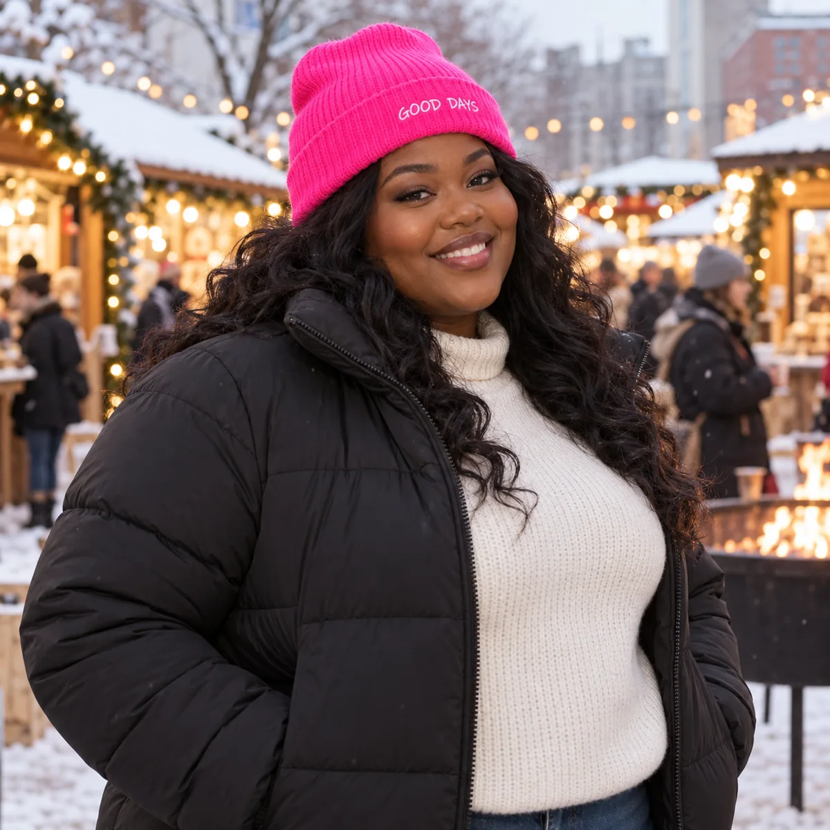 Black woman wearing a neon pink Sportsman beanie with fictional Good Days embroidery at a winter market.