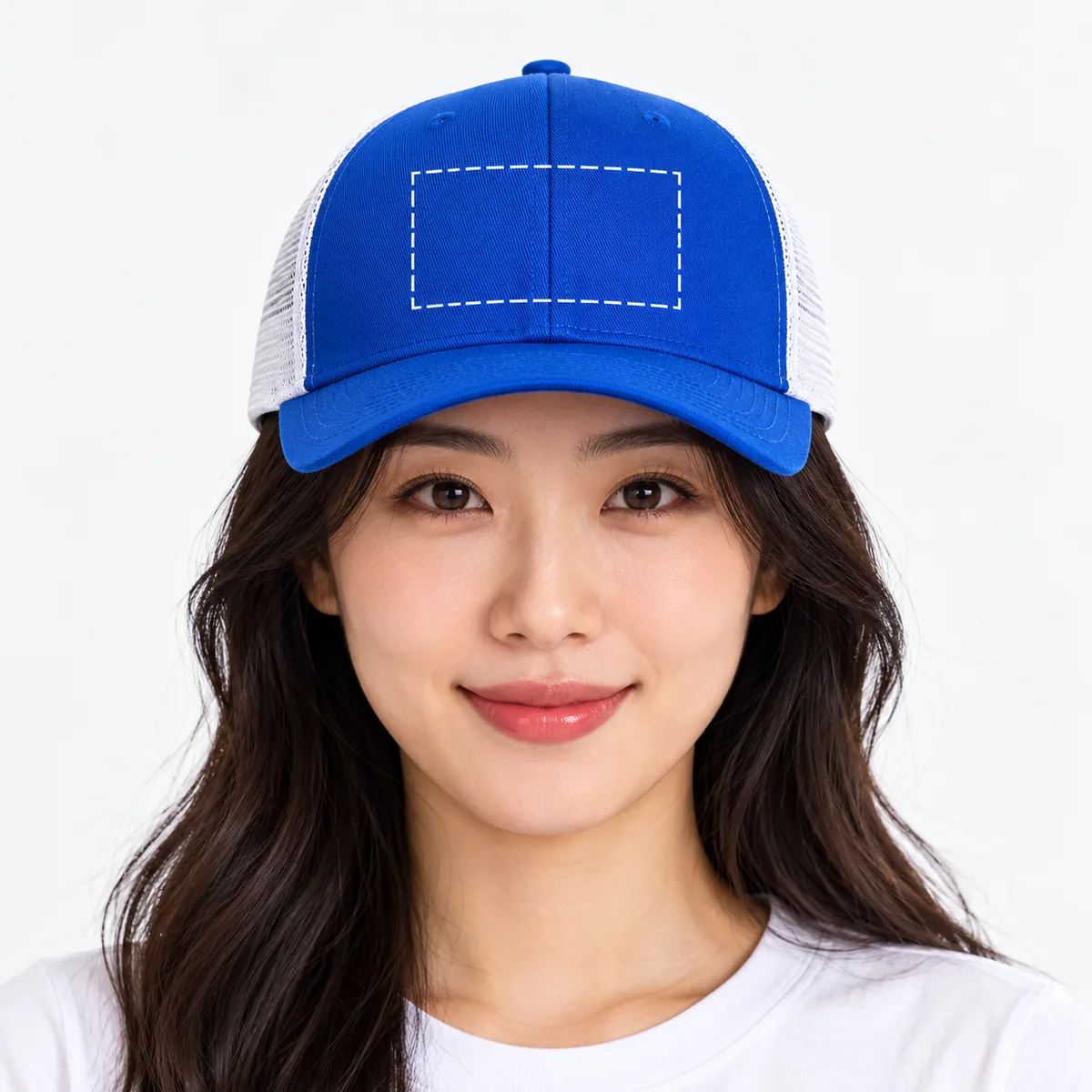 Woman wearing a royal blue and white trucker cap with an illustrative dashed front-panel embroidery placement guide; dimensions are not verified.